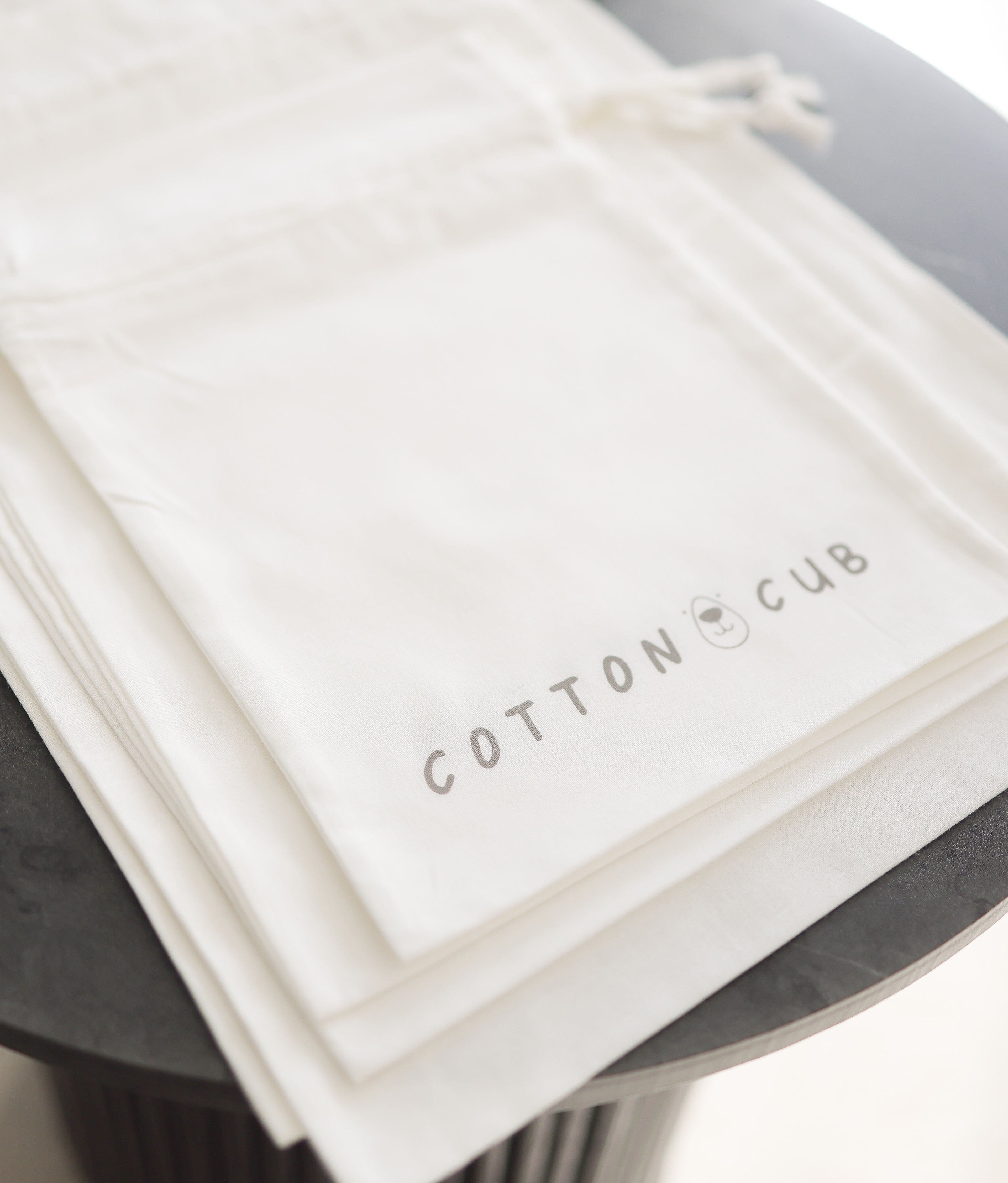 White product packaging with 'Cotton Cub' branding on a dark surface
