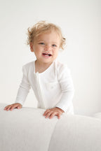 Child wearing a white outfit on a white background